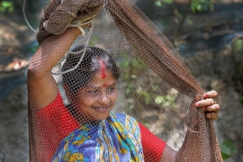 The woman taking preparation to throw fishing net to her pond in Khulna, Bangladesh. Photo by M. Yousuf Tushar. April 18, 2014